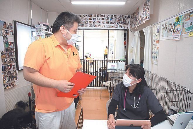 左は介護チーフスタッフ、堀内章さん。獣医師と犬の健康状態についての打ち合わせ