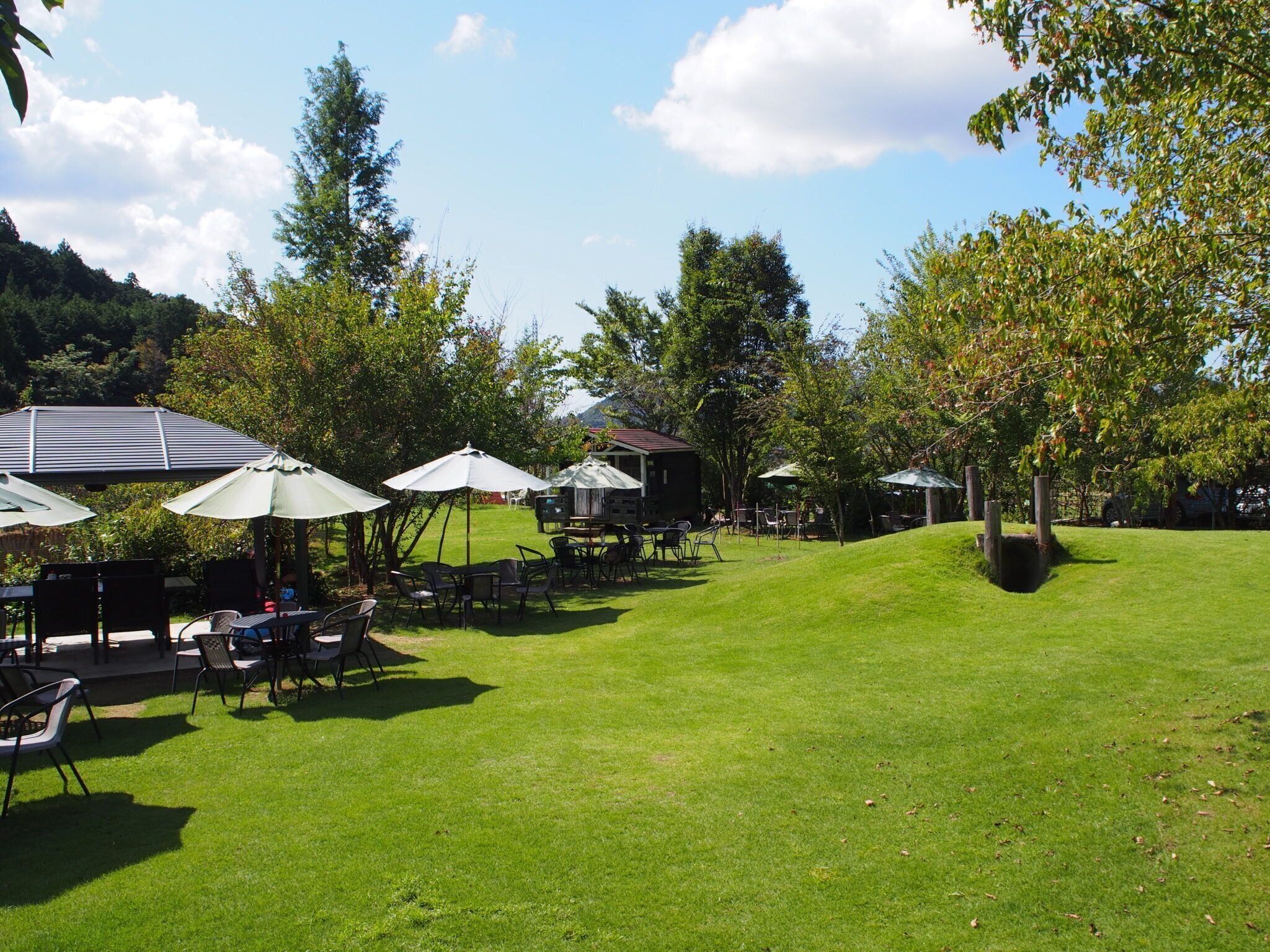 パラソル、テーブル、椅子が配置されたドッグラン