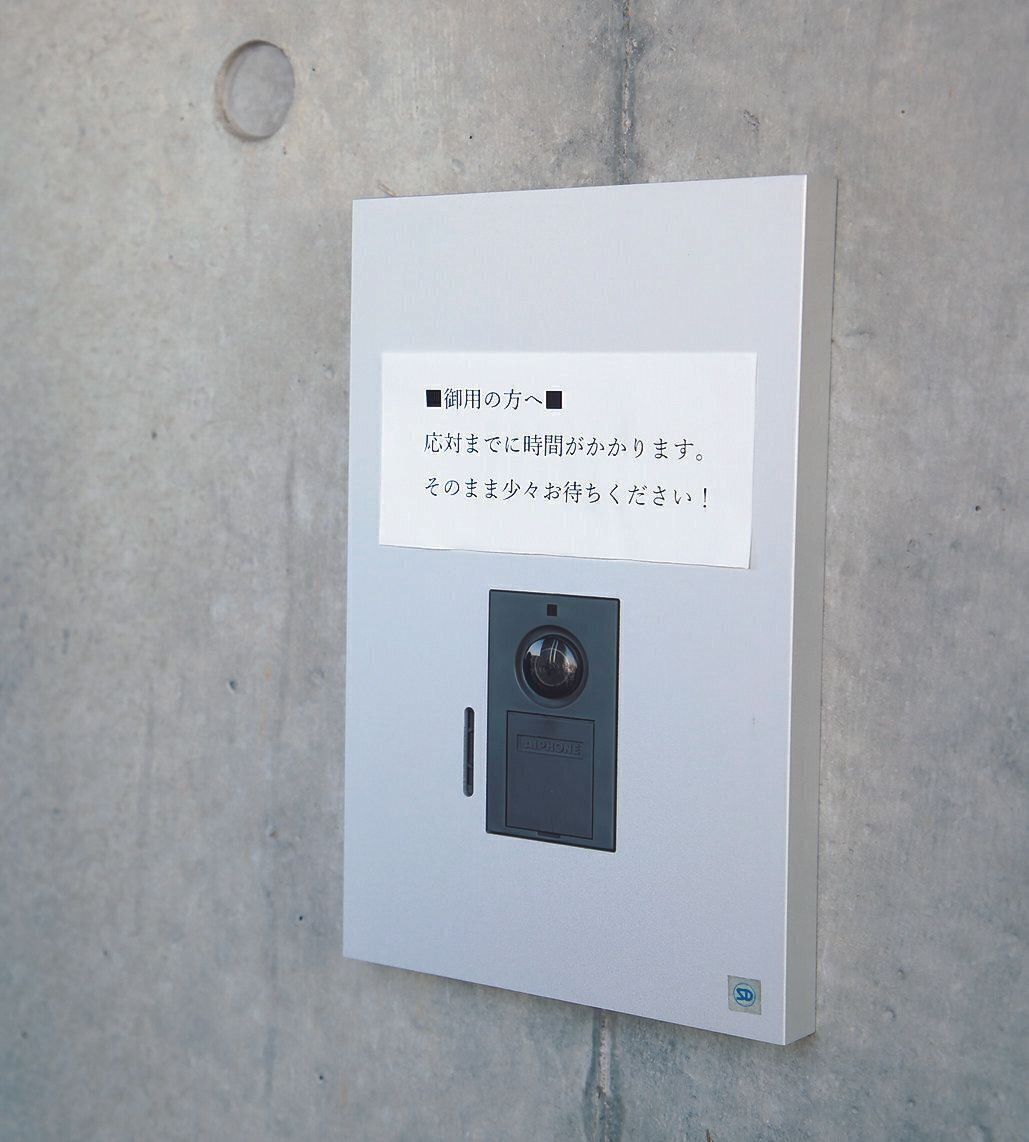 玄関の呼び鈴の上に張り紙をする