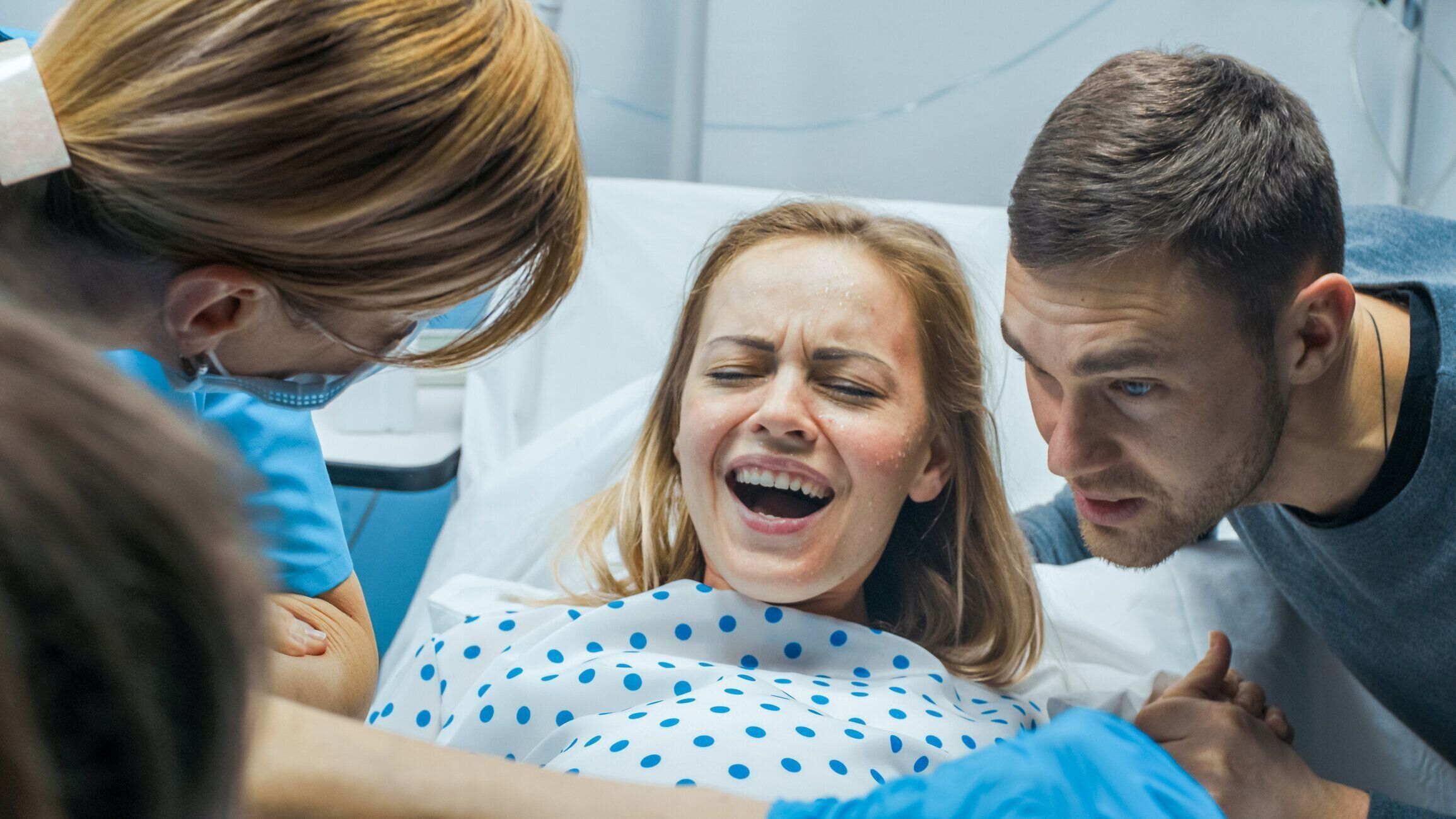 出産、産科医、支援する労働のプッシュで女性の病院のクローズ アップでは、夫は彼女の手を保持します。モダンな配達区助産師。