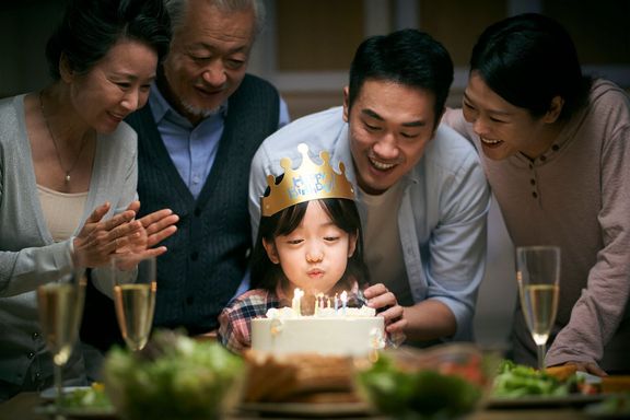 家で小さな女の子の誕生日を祝うアジアの3世代の家族