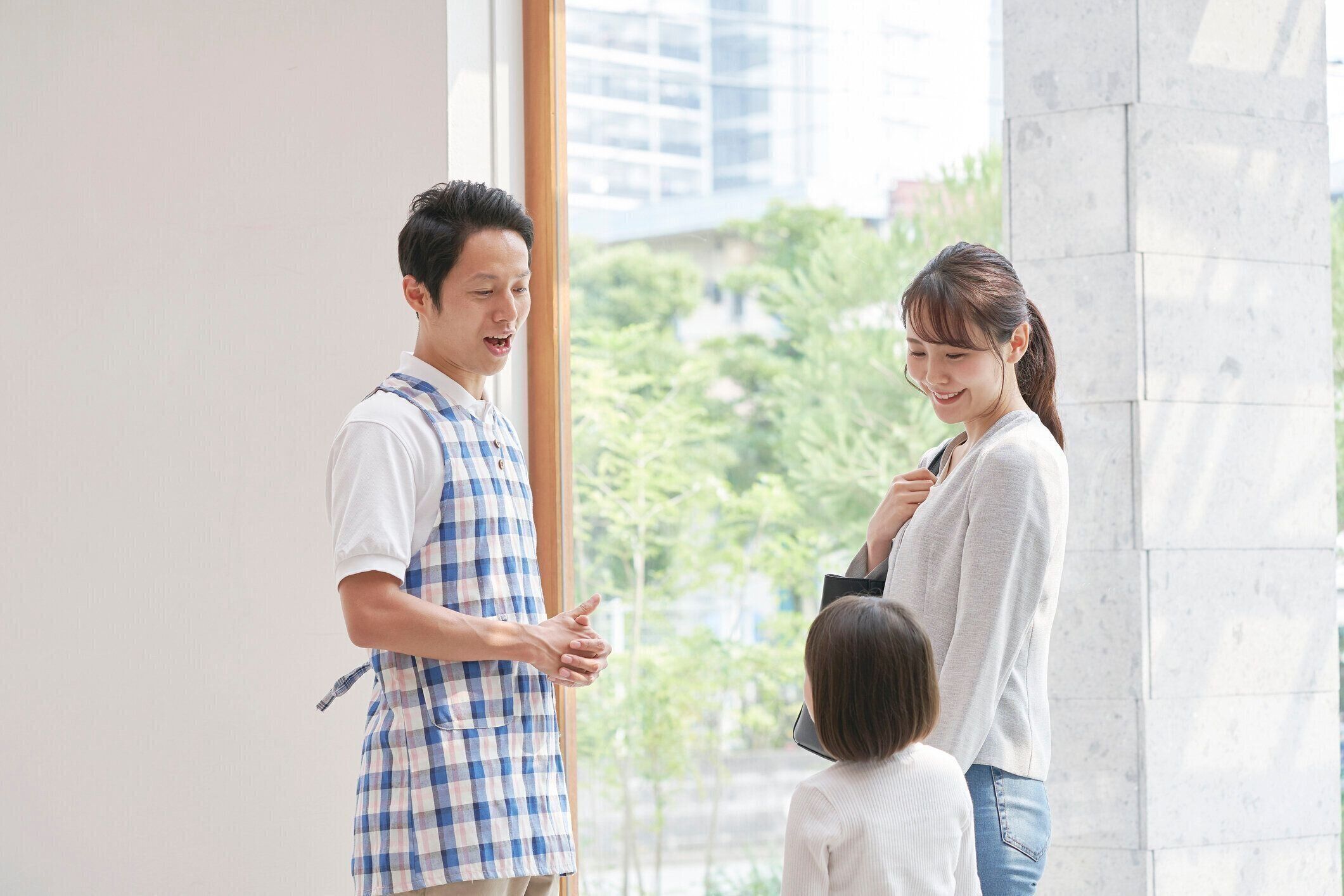 女の子の母親と話しているアジアの保育士