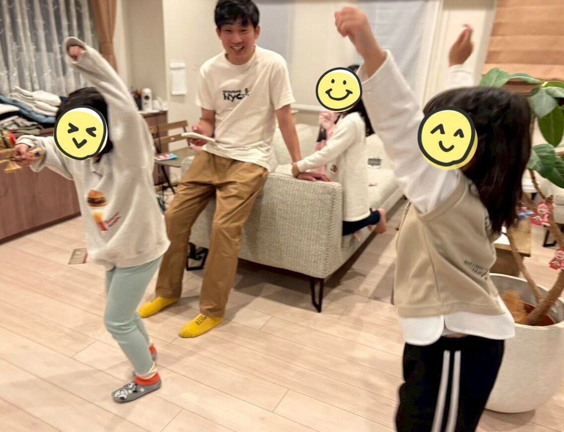 ダンスをする姉妹たち。見守る石田さんは、優しいパパの表情。