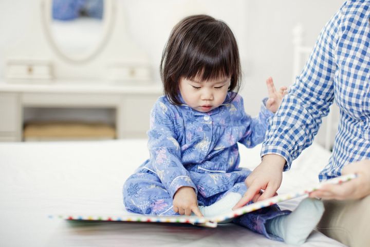 家でお母さんと本を読んで女の赤ちゃん