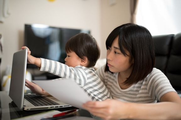 若い母親は彼女の子供と家の中の作業