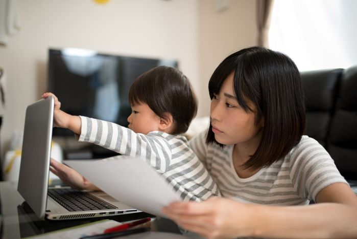 若い母親は彼女の子供と家の中の作業