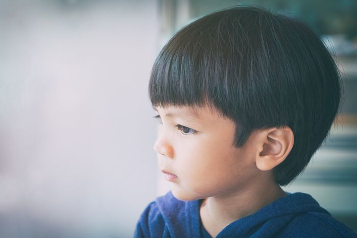 真剣に窓の外を見てアジアの少年