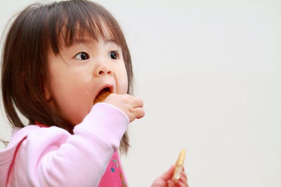 おせんべいを食べる日本人の女の子