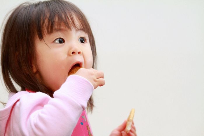 おせんべいを食べる日本人の女の子