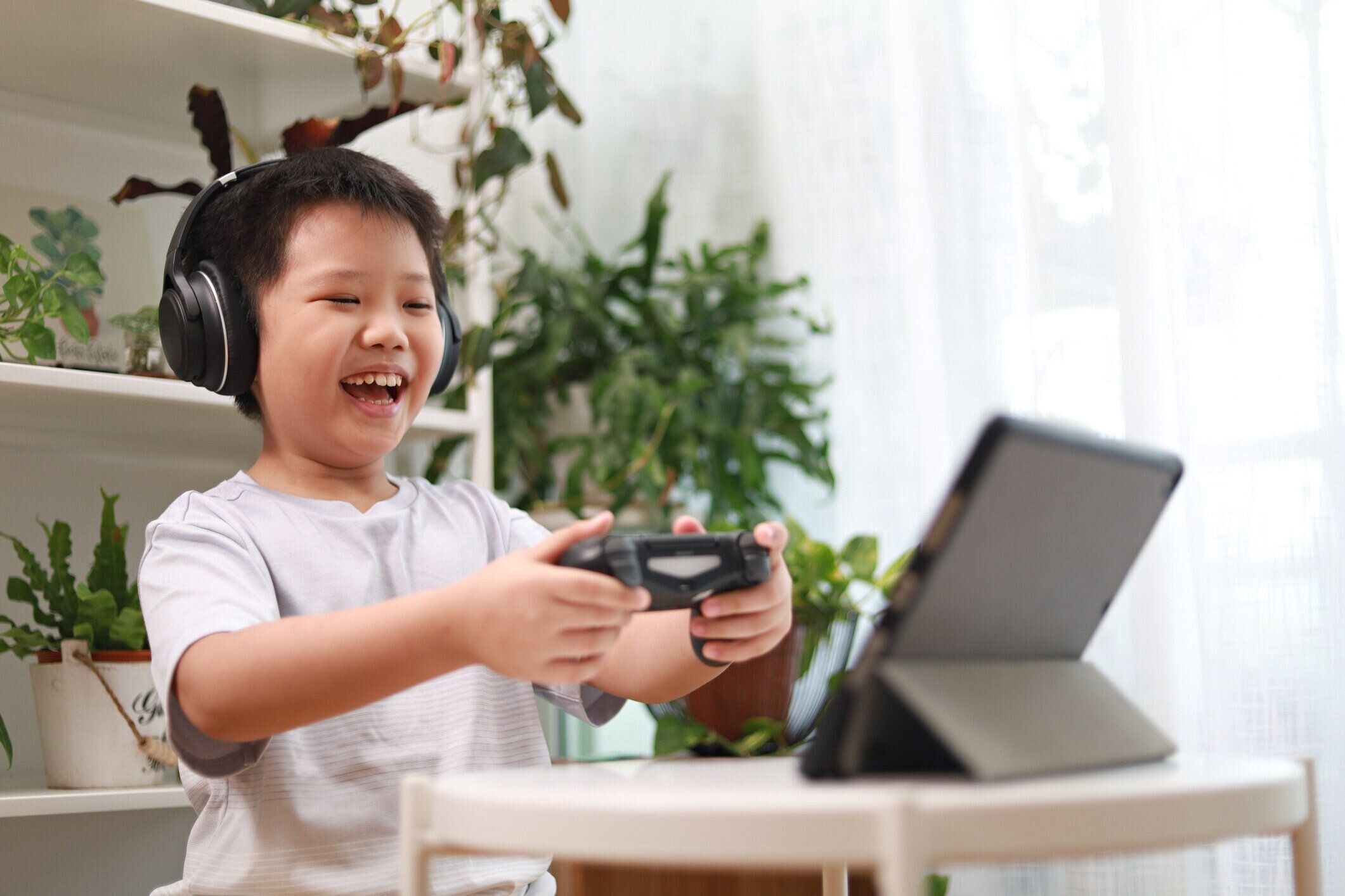 自宅でタブレットコンピュータでビデオゲームをプレイ少年