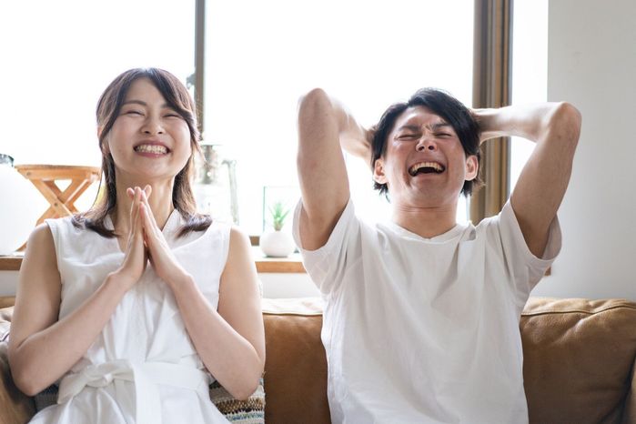 自宅でスポーツの試合を見ているカップル