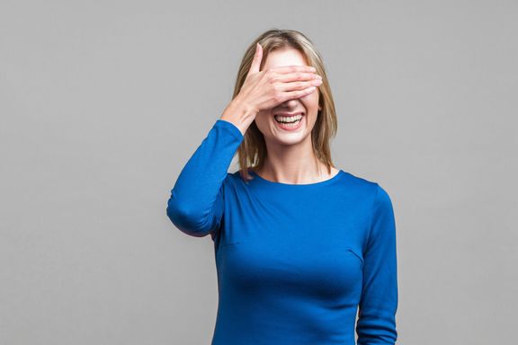 だから恥ずかしい、私はむしろこれを見ない!目を手で覆う恥ずかしがり屋のポジティブな女性の肖像。灰色の背景で分離
