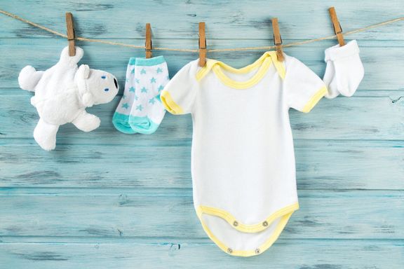ベビー服、ワンシー、靴下、白いクマのおもちゃを物干しに