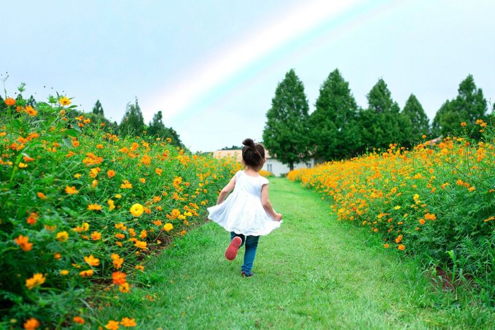 虹に向かって走っている少女
