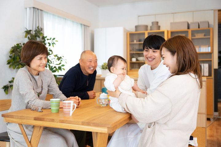 自宅のリビングで赤ちゃんを抱くことができる3世帯男女5人