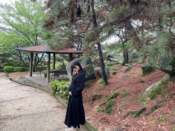 公園へお出かけ中、ふっくらしてきたおなかを抱える矢島さん