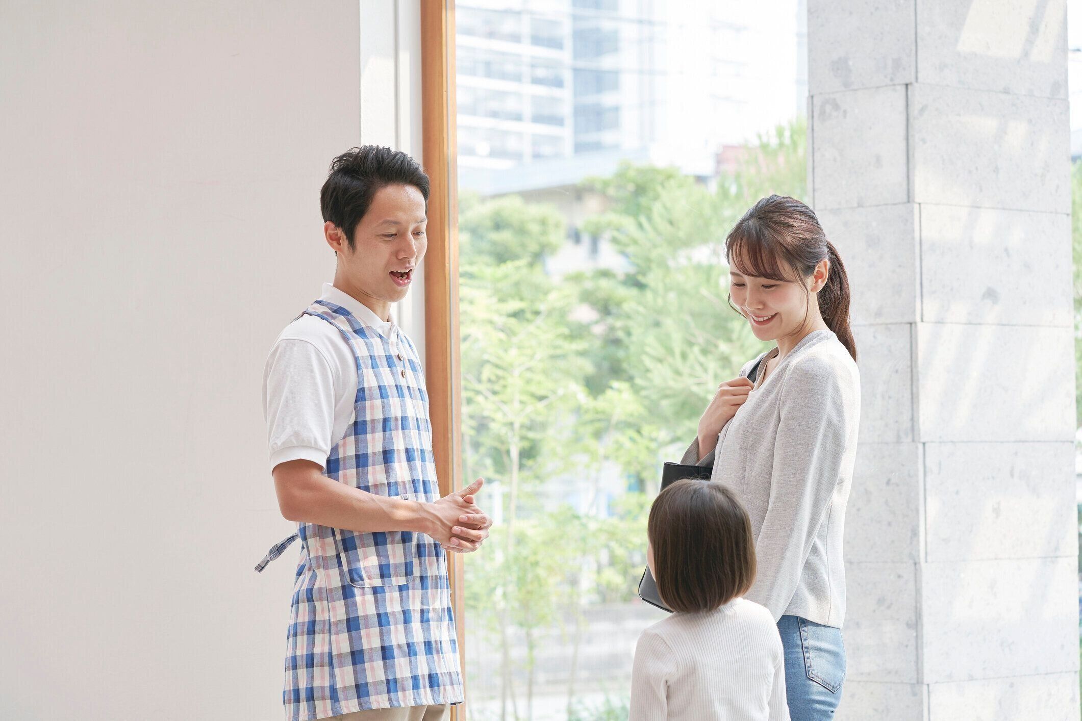 女の子の母親と話しているアジアの保育士