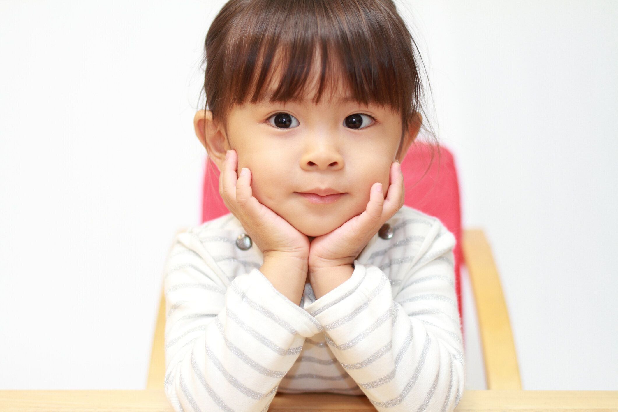ほおづえについて彼女の手 (3 歳) で日本の女の子