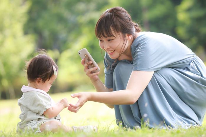 スマートフォンで子供を撃つ母親
