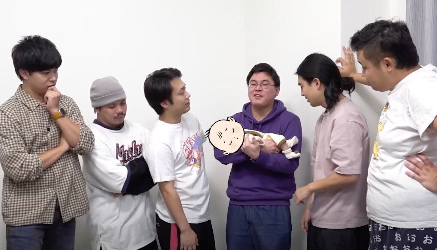 息子さんお披露目の様子。メンバー一人一人に息子さんを抱っこしてもらっている