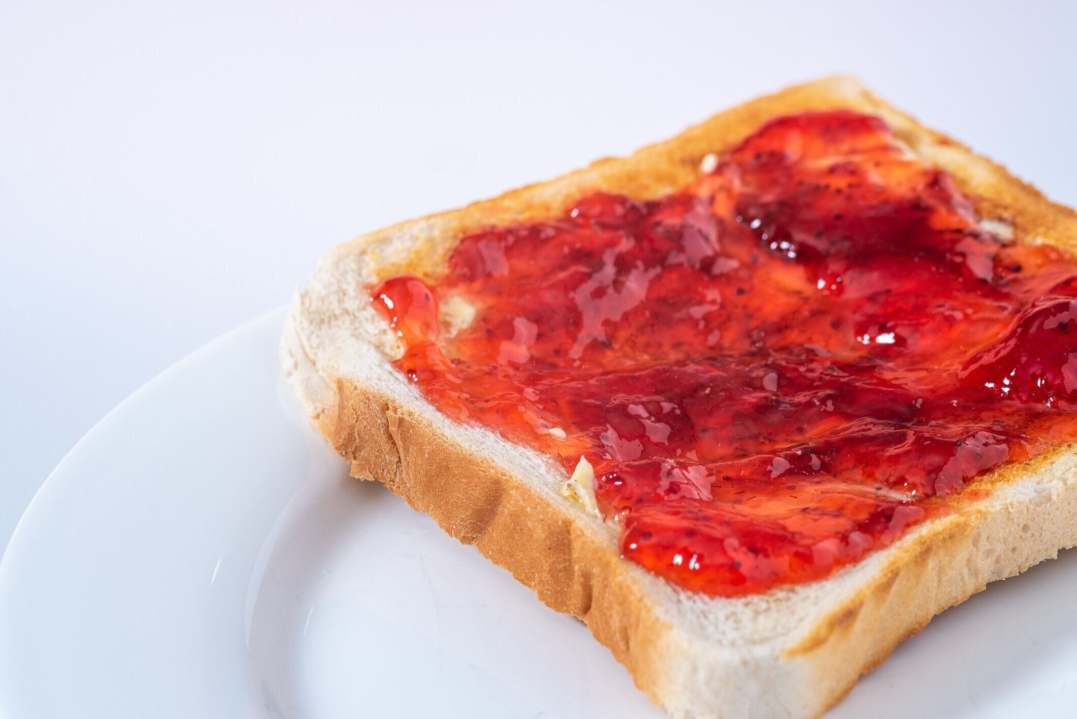 白い皿にイチゴジャムを入れトースト