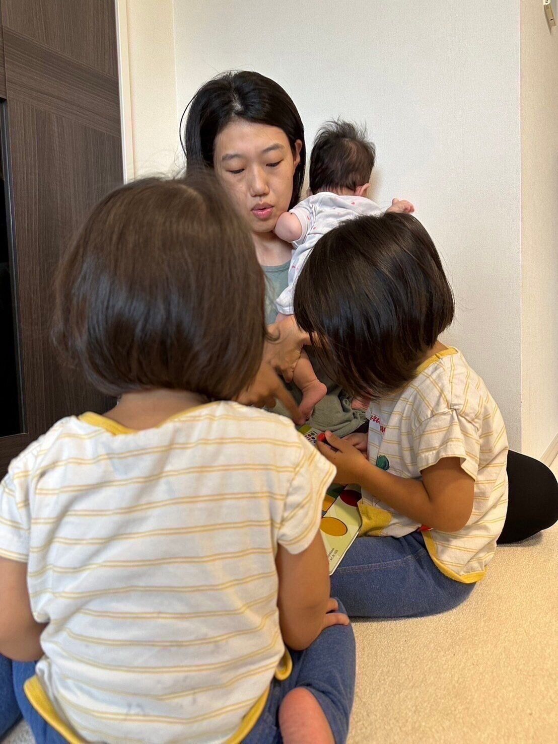 三女を抱っこしながら、上の二人のお子さんと遊ぶ横澤さん。
