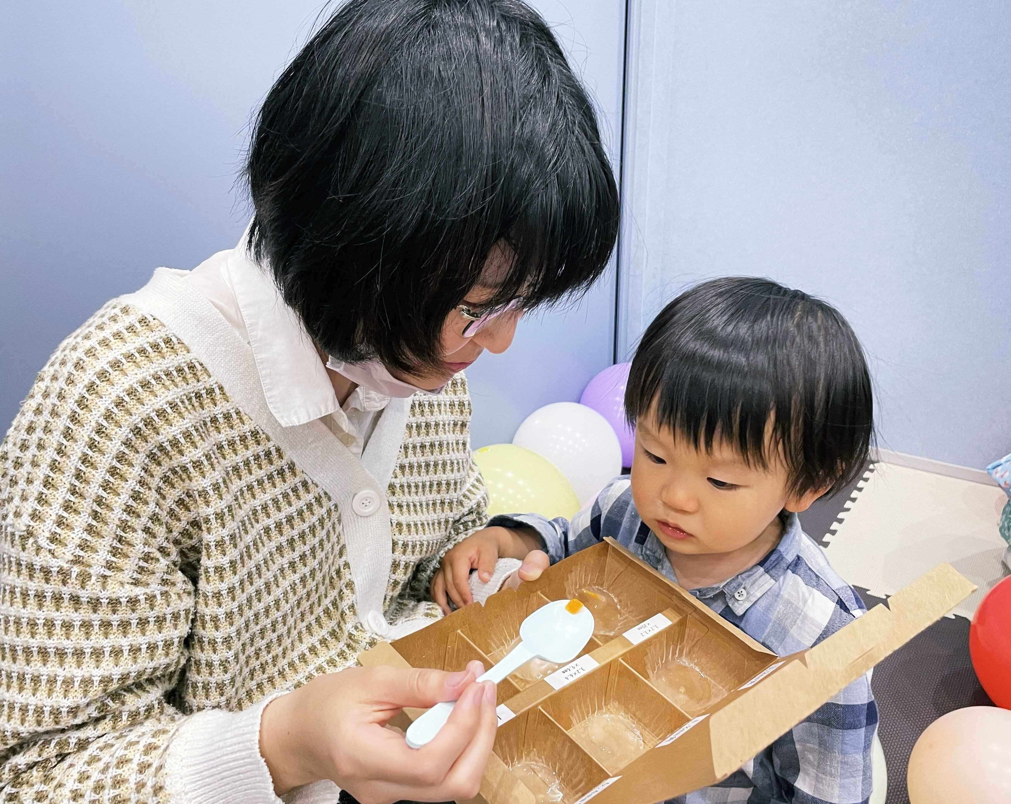 ベビーフードを試食する親子