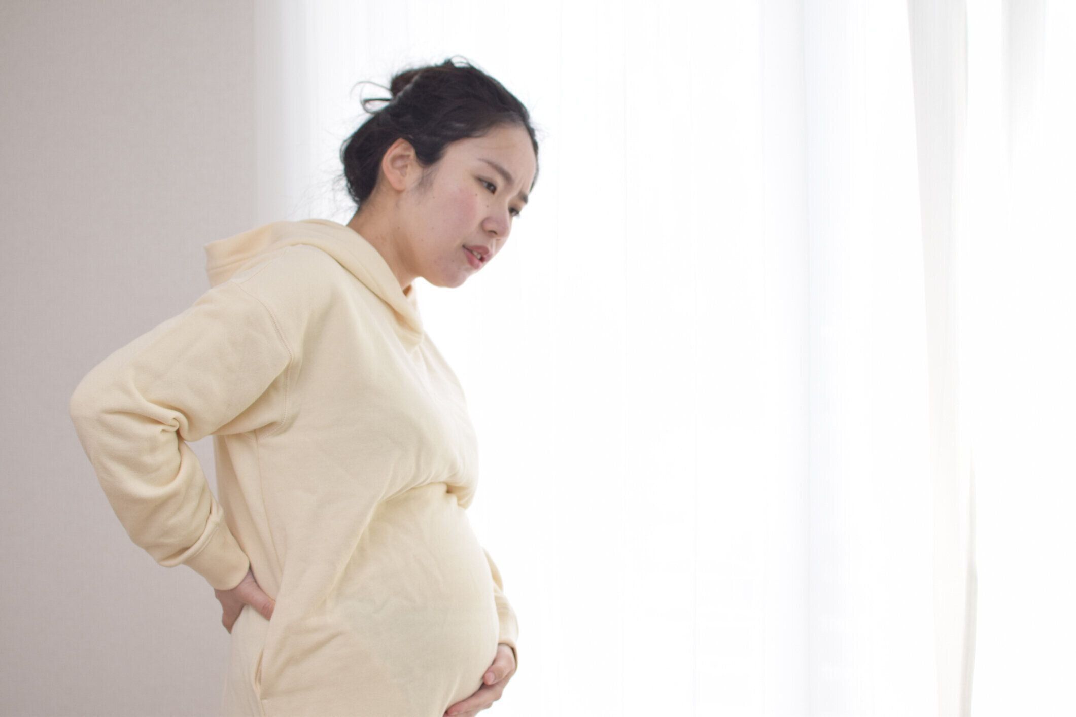 背中の痛みを伴う若い妊婦