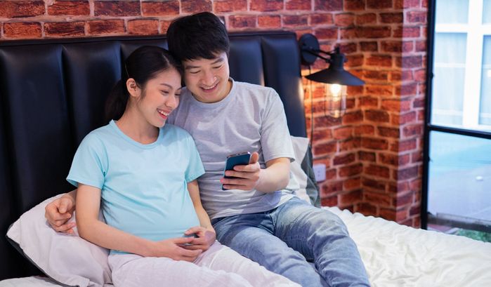若いアジアの新婚夫婦は妊娠して幸せ