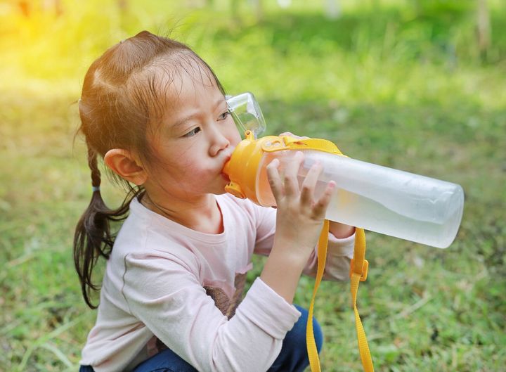 少女が公園でボトルから水を飲むを閉じます。屋外の肖像画。