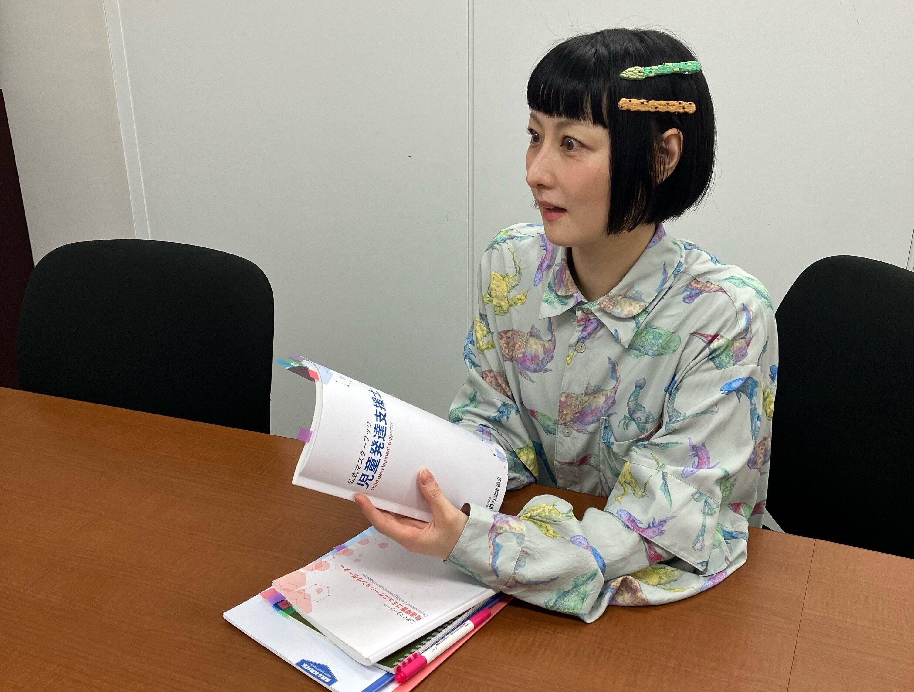 二つの資格のテキストを手にする、鳥居みゆきさん。