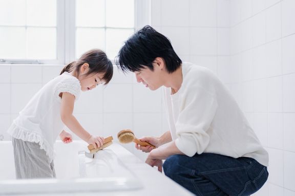 パパと一緒にお風呂を掃除する小さな女の子