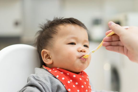 ハイチェアでブレンドフードを食べるアジアの男の子