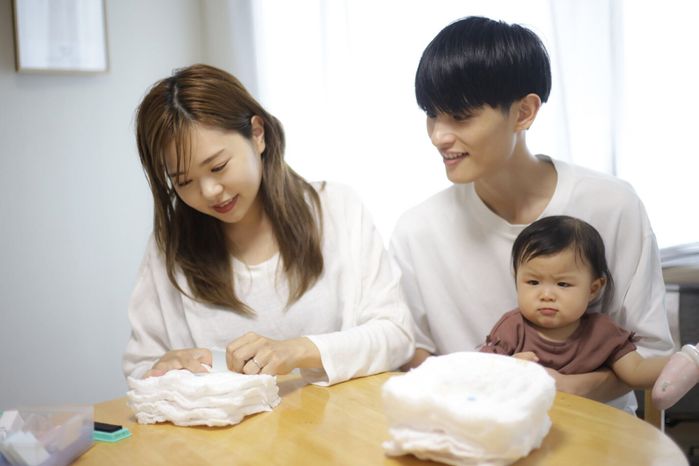 おむつにネームスタンプを押すお母さん