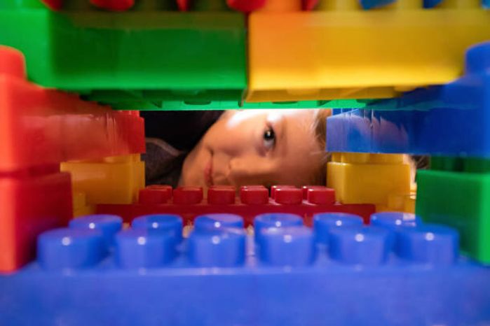 バック グラウンドでの子供とおもちゃのブロックのクローズ アップ。