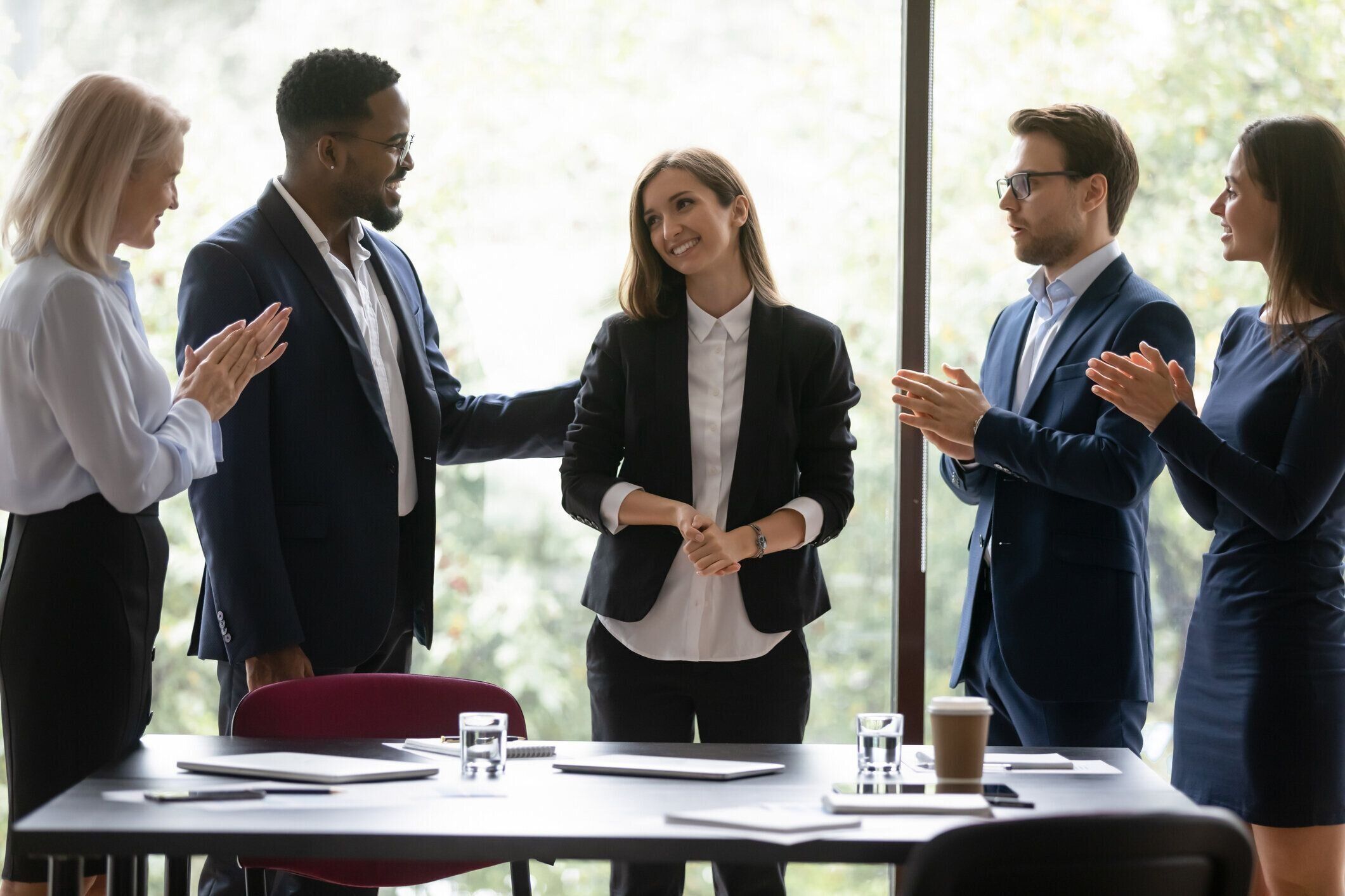 多民族の同僚は、成功で女性リーダーを祝福拍手