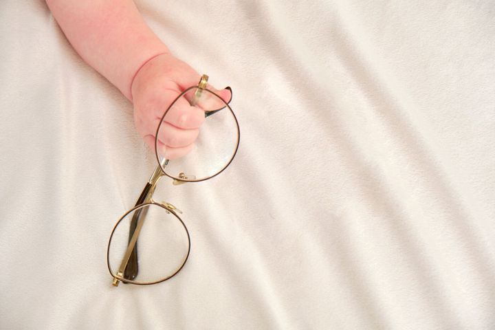 眼鏡をかけた幼児の男の子の手。眼鏡フレーム、クローズアップの子供