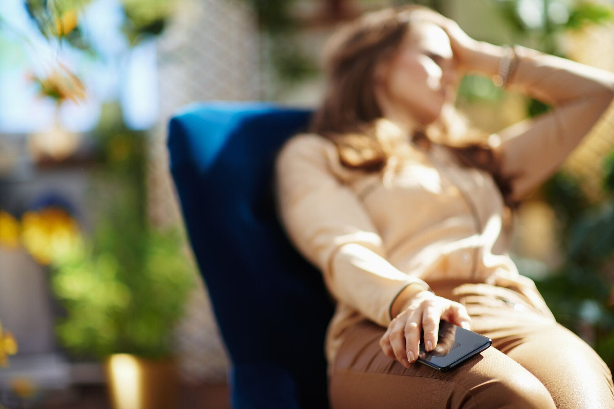 晴れた日に自宅で長い波状の髪を持つストレスの女性