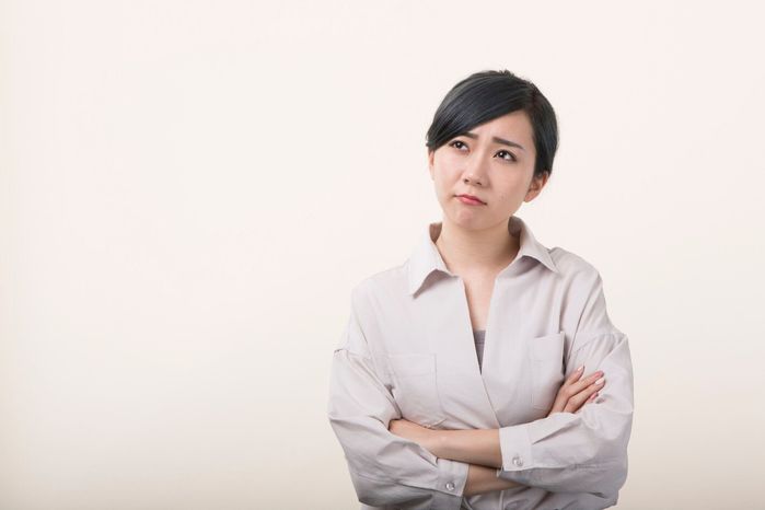 若い女性の腕を心配そうな顔を示す交差