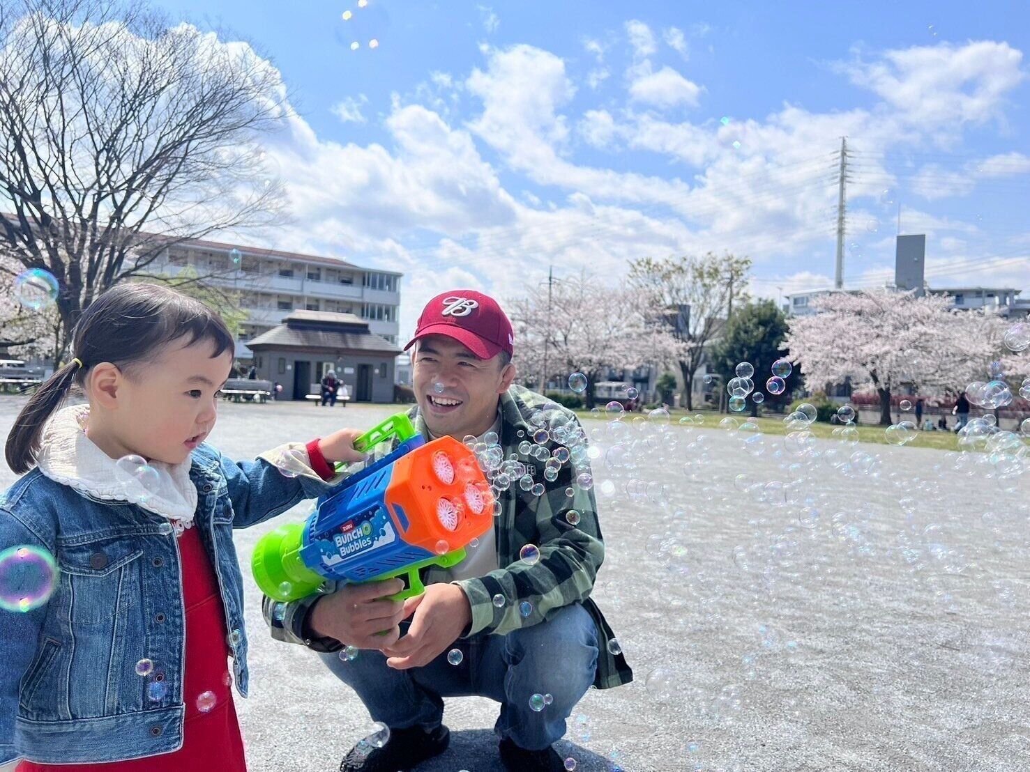 公園でシャボン玉をして遊ぶ、文田さんと長女。