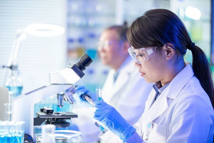 アジアの科学者使用顕微鏡
