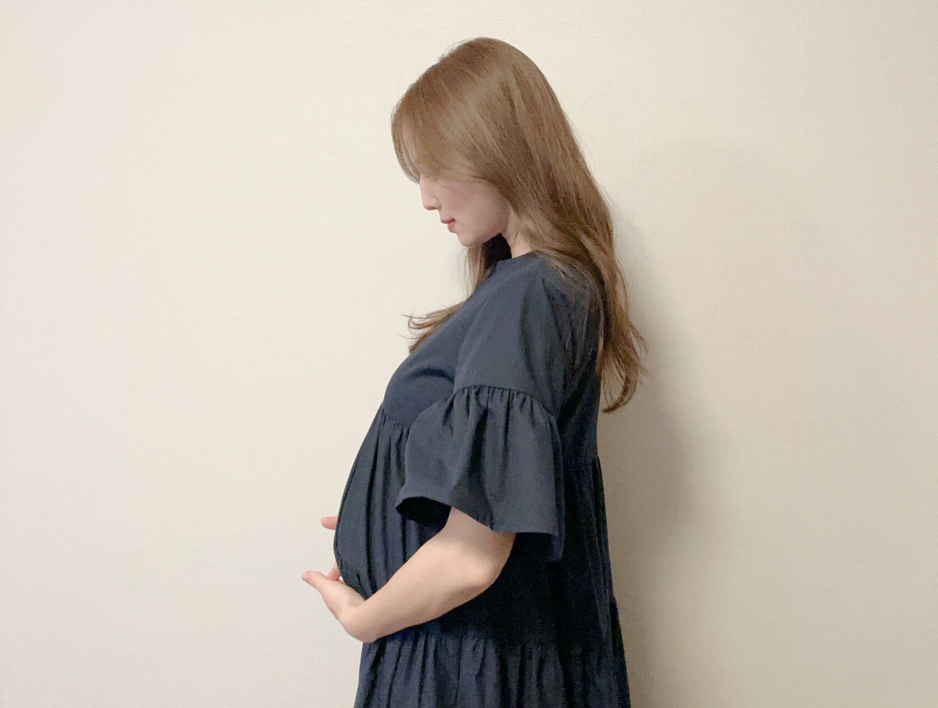 おなかをやさしく抱える、丸高さん。