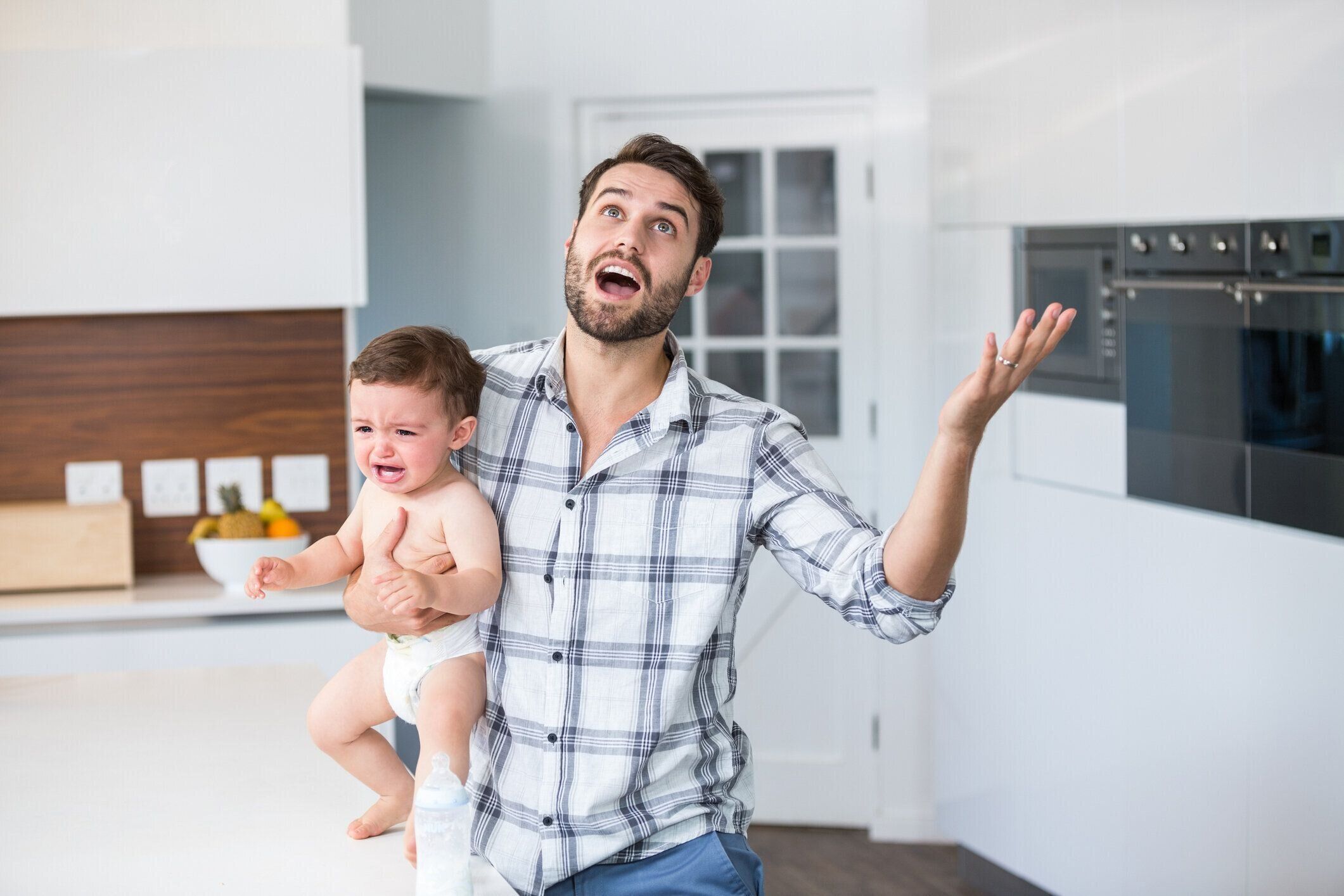 キッチンでフラストレーションの父持株泣いている男の子