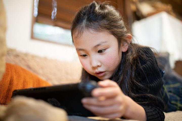 ソファでゲームをしている女の子