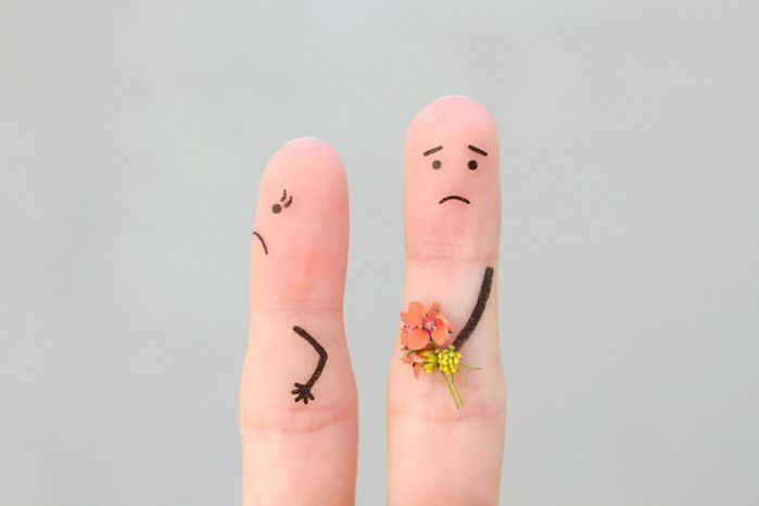 カップルの指の芸術。男は女性に花束を与える、彼女は満足していない。