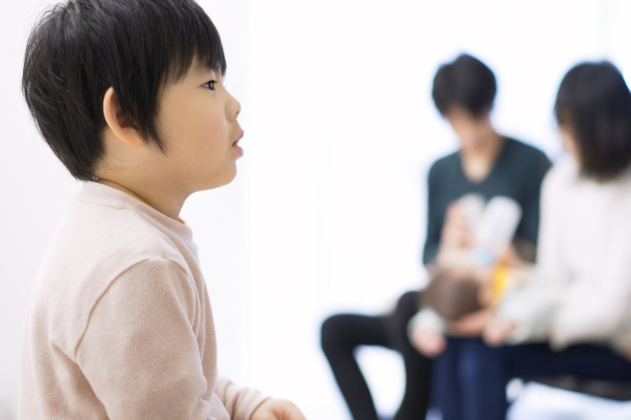 赤ちゃんを母乳で育てながら静かにテレビを見ている幼児