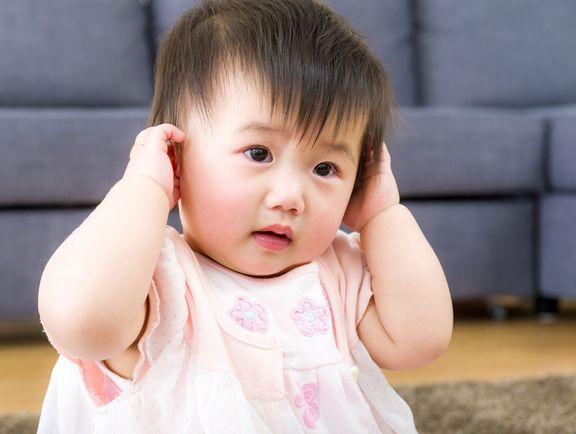 小さな女の子の手を使って耳をカバー