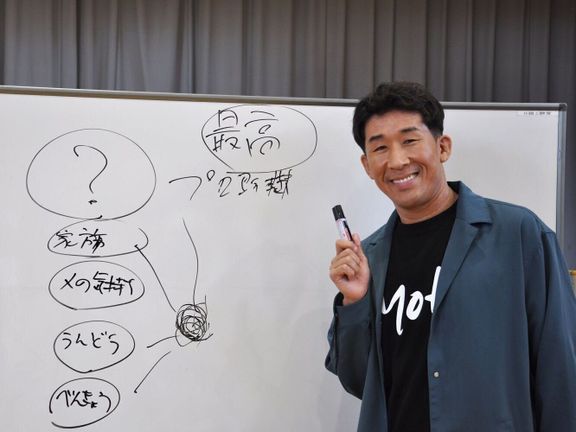 小学校で講演をする田村さん。
