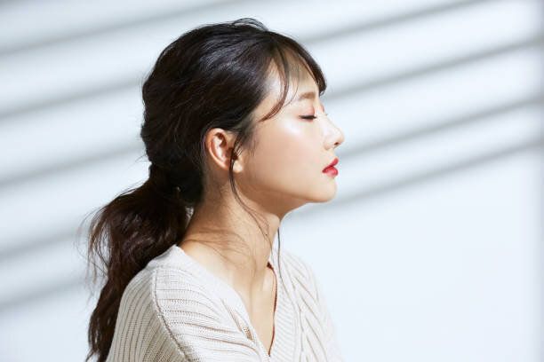 光と影の背景に若いアジアの女性の美の肖像画