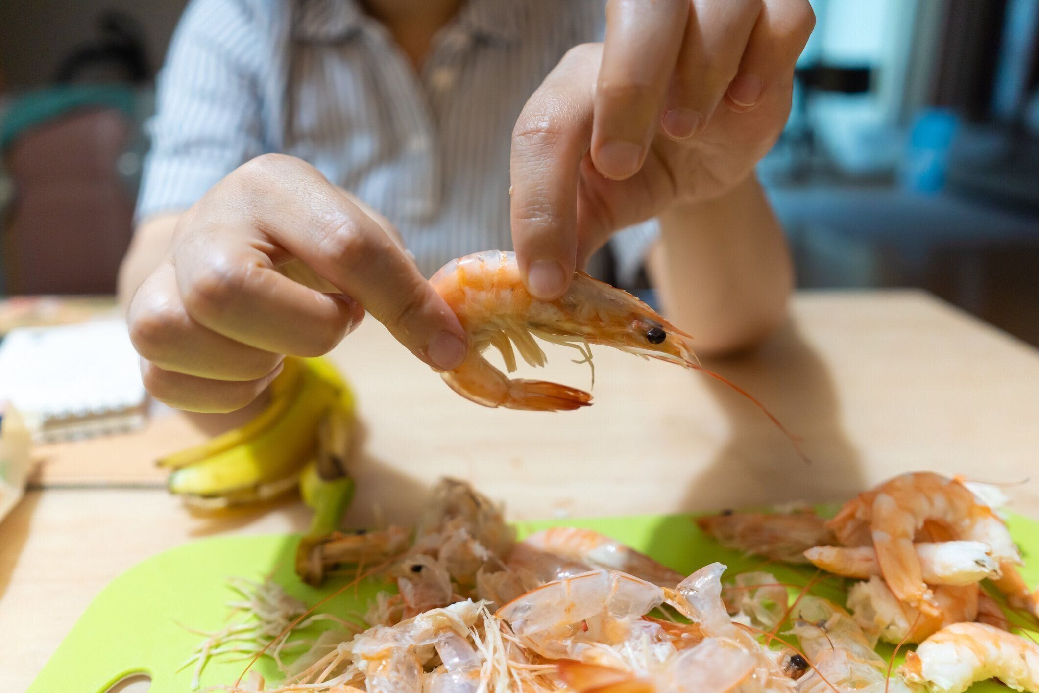 蒸しエビを手で剥がす女性
